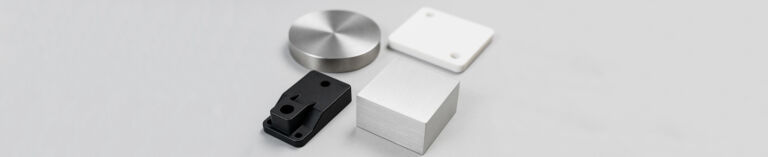 Close-up of high-quality metal raw materials (including aluminum alloy and carbon steel bars) for mechanical machining, neatly stacked in a manufacturing workshop.