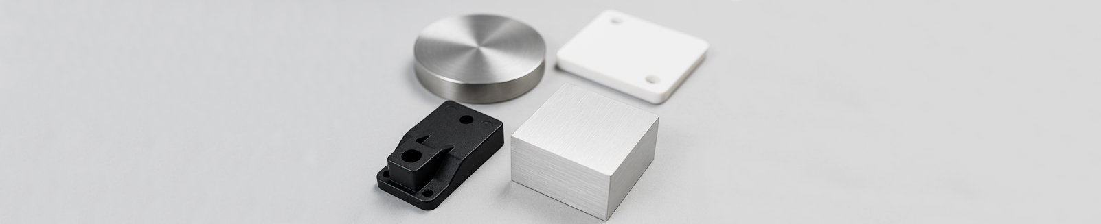 Close-up of high-quality metal raw materials (including aluminum alloy and carbon steel bars) for mechanical machining, neatly stacked in a manufacturing workshop.