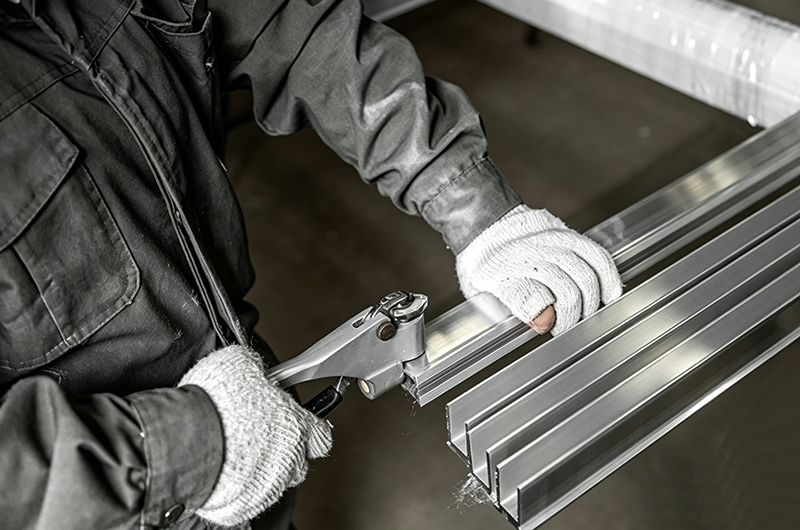 Brushed aluminum process for CNC machined metal parts, showing uniform linear surface finish on aluminum workpiece in mechanical manufacturing workshop.