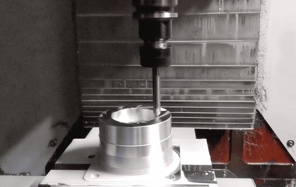 3-axis CNC machine executing small batch machining of metal components, showcasing precision cutting tools and workholding fixtures
