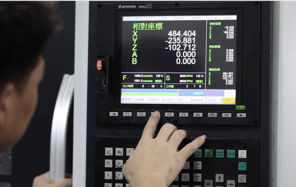 Engineer fine-tuning CNC programming tweaks on a control panel to optimize machining processes in a precision workshop